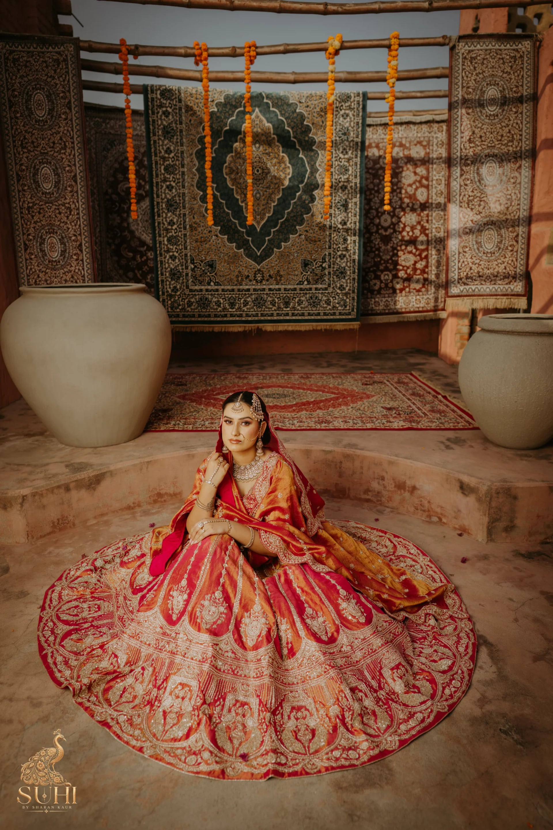Bride in the MEHRUNISA royal red bridal lehenga with intricate golden embroidery
